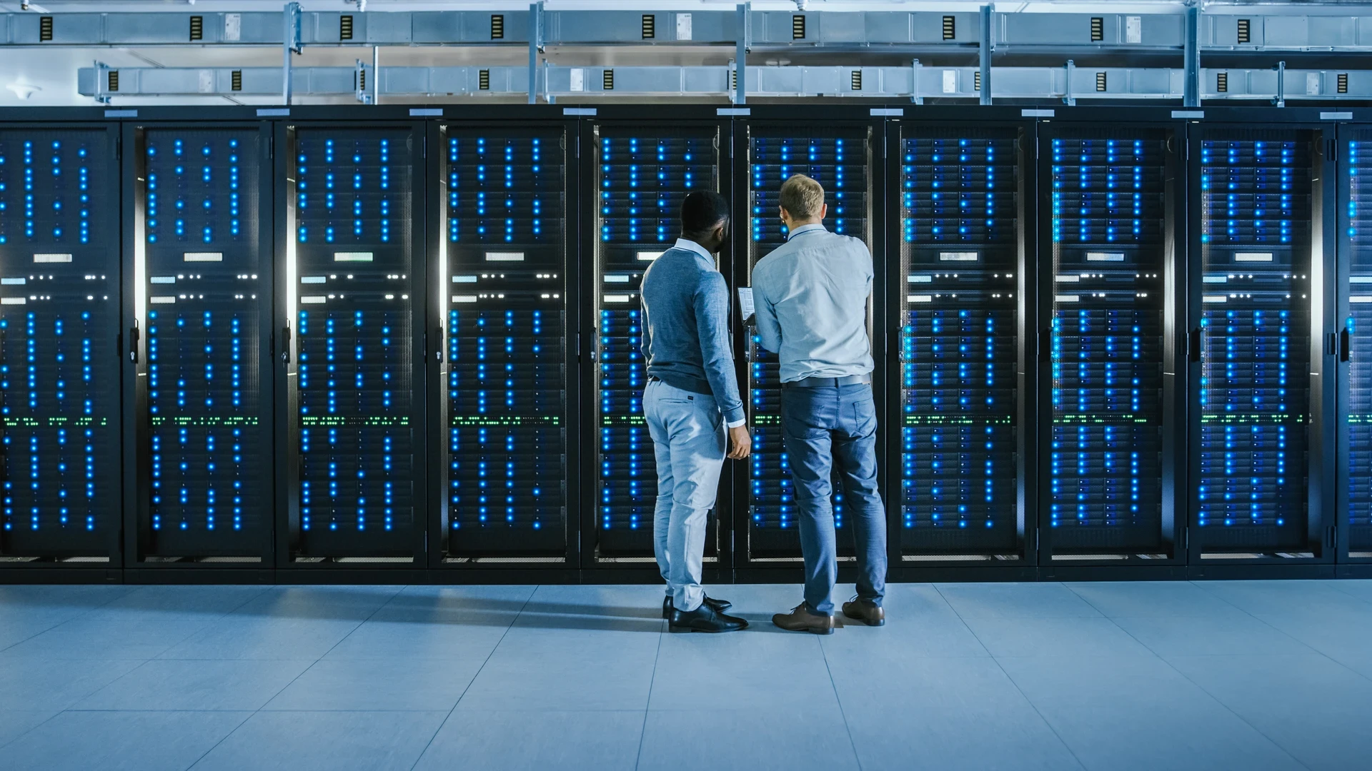 men standing in front of data center server racks