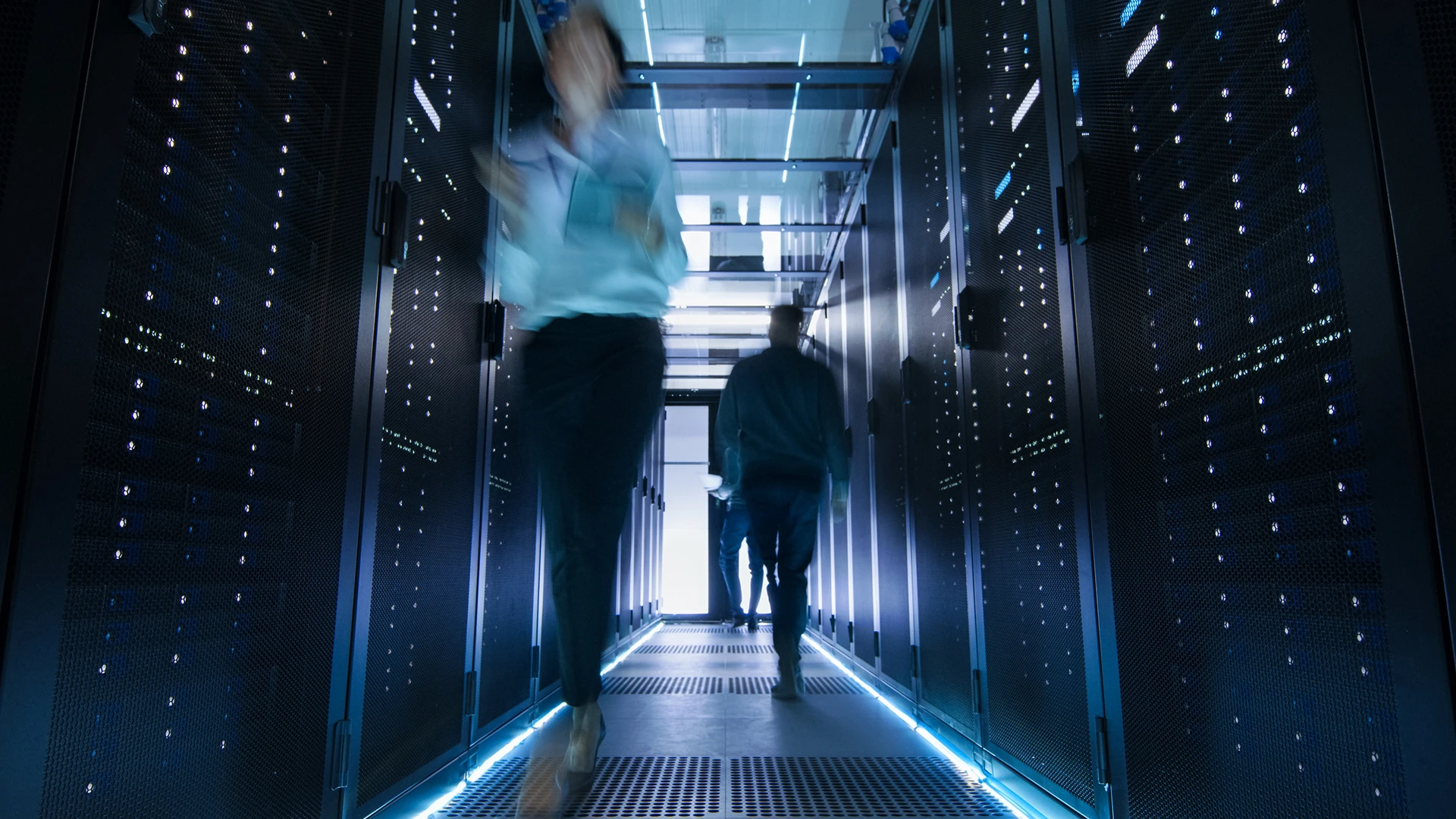 People walking next to servers in data center