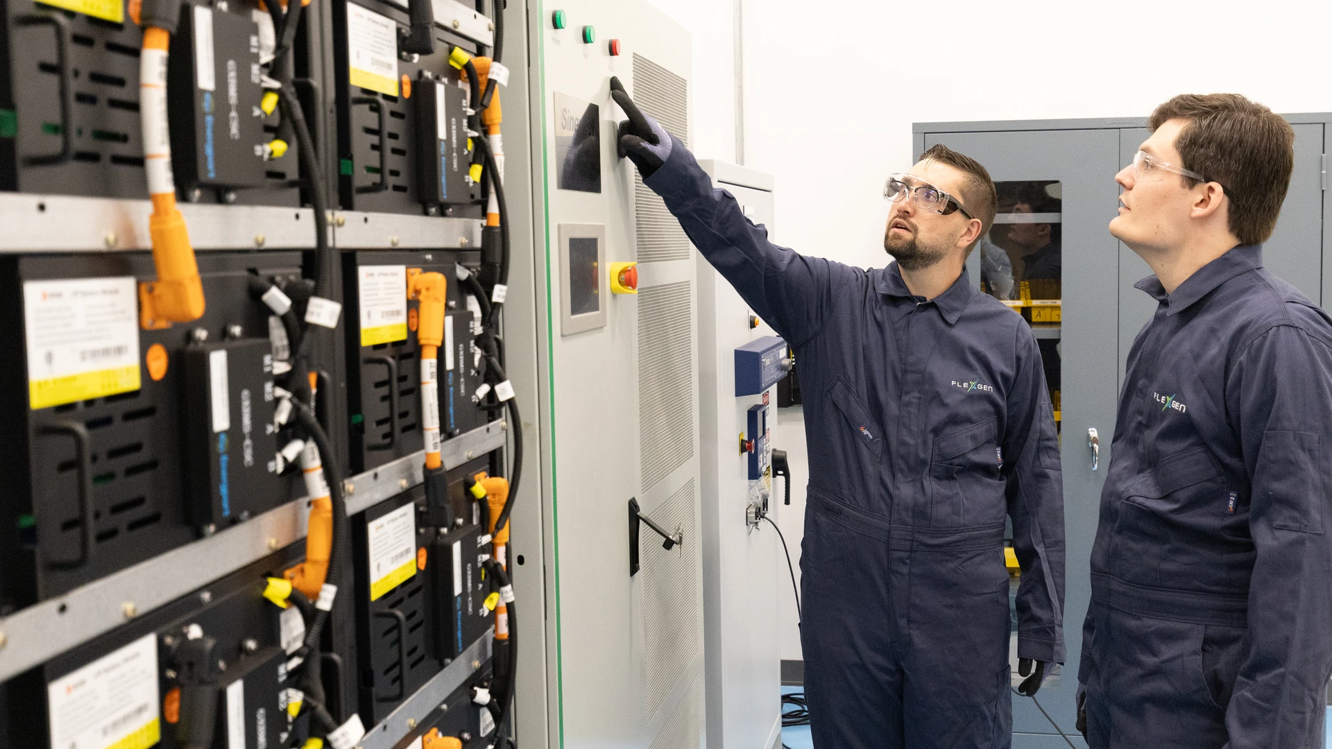 Two people in front of battery energy storage system in lab