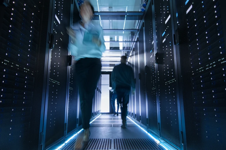 People walking next to servers in data center