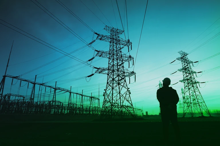 Profile of person standing by power grid infrastructure