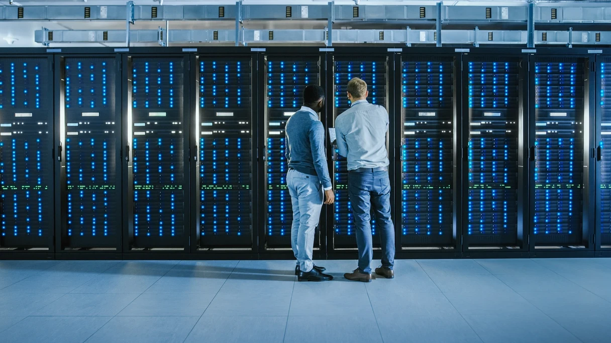 men standing in front of data center server racks