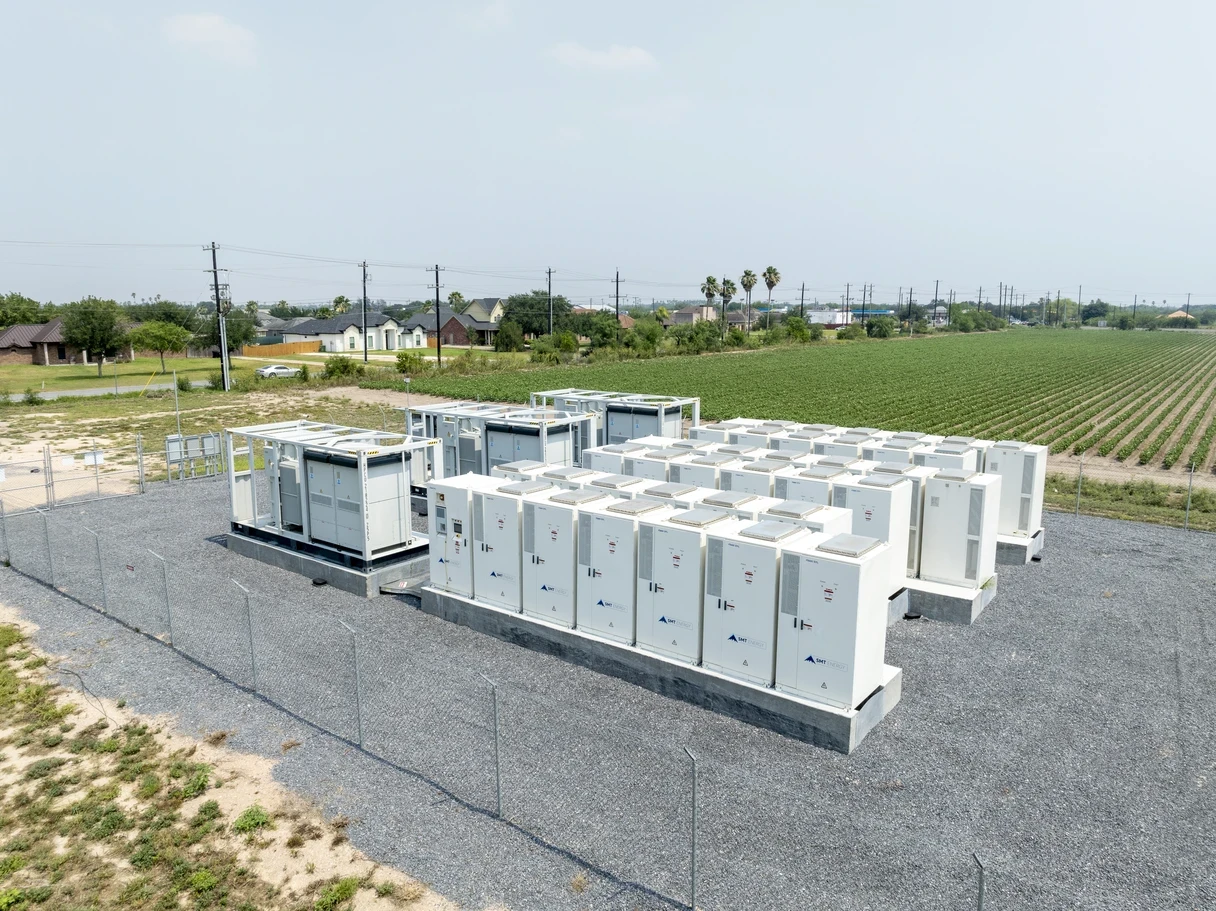 A modern battery energy storage system (BESS) installation in a rural setting, supporting grid reliability and renewable energy integration.